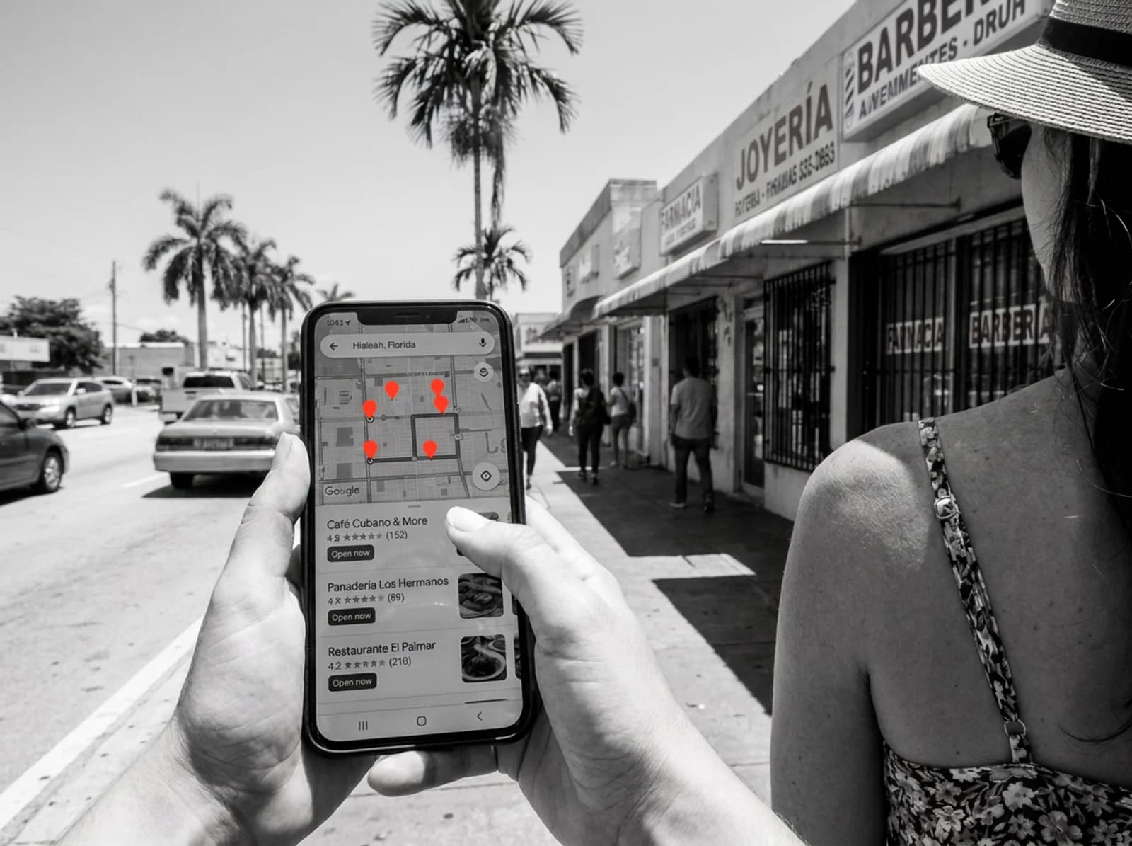 Customers pick inside the Local Pack, before they reach your website Woman on a Hialeah sidewalk choosing a business from the Google Maps Local Pack on her phone