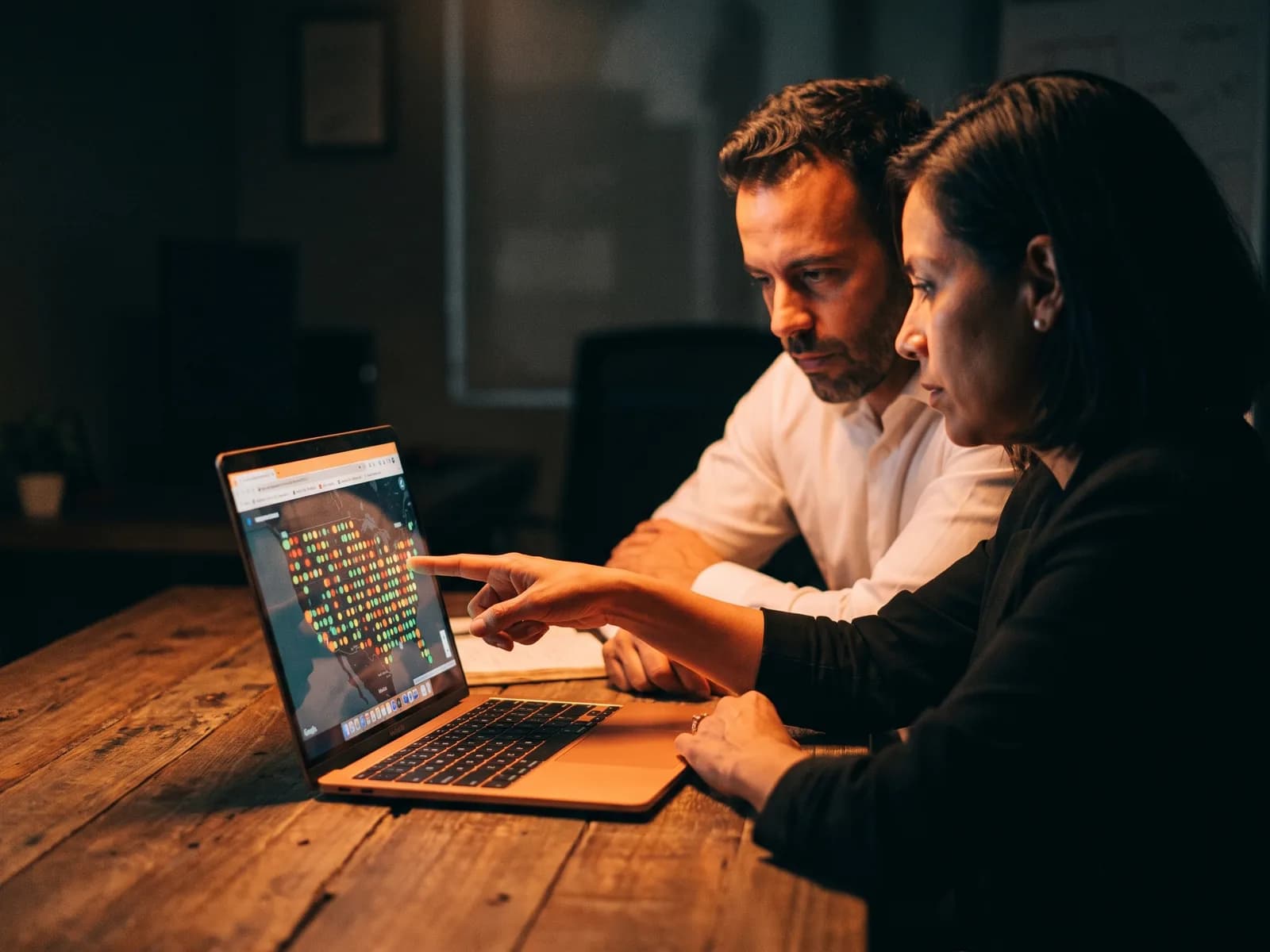 A tamer Marketing strategist and a business owner reviewing a map grid of local rankings on a laptop A tamer Marketing strategist and a business owner reviewing a map grid of local rankings on a laptop