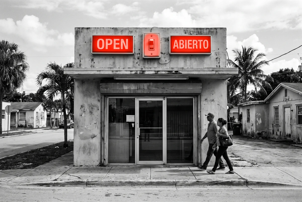 Two orange signs over one door reading OPEN and ABIERTO with a switch between